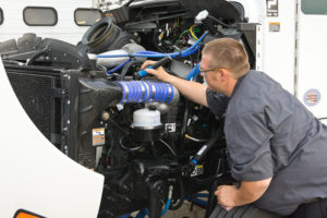 A skilled mechanic focuses on a truck engine, representing the convenience of mobile auto repair services.