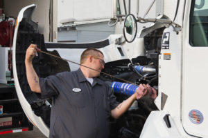 A mobile mechanic is diligently repairing a truck, showcasing expertise in vehicle maintenance and service.