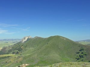 Scenic view of hills and mountains from a hilltop in Aptos, California, showcasing lush greenery and distant peaks.