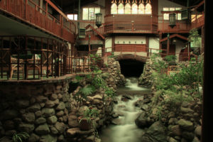 A stunning waterfall flows through a structure in Brookdale, California, with an additional waterfall seen in the backdrop.