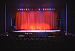 A theater located in Rio Del Mar, California, displaying a stage with vibrant red curtains, poised for an upcoming show.