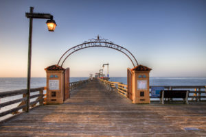 Scenic pier in Soquel, California, showcasing a wooden walkway and a beautifully illuminated archway at dusk.