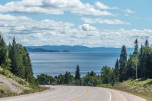 A beautiful road in Zayante, California, bordered by trees and showcasing a peaceful water scene in the distance.